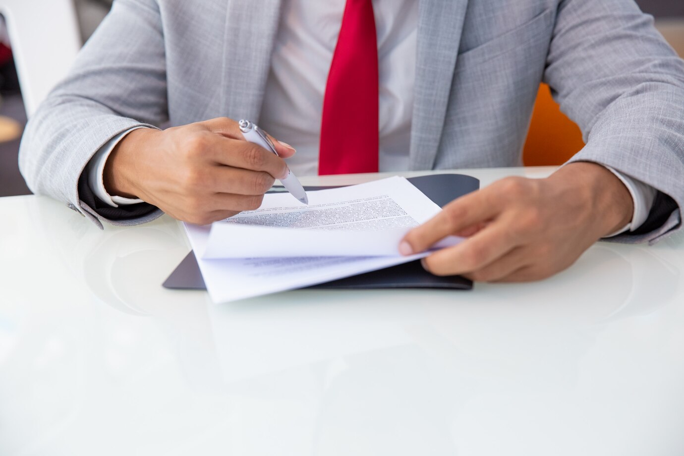 A professional man in a suit signing a document, symbolizing the work of employment lawyers in Perth.