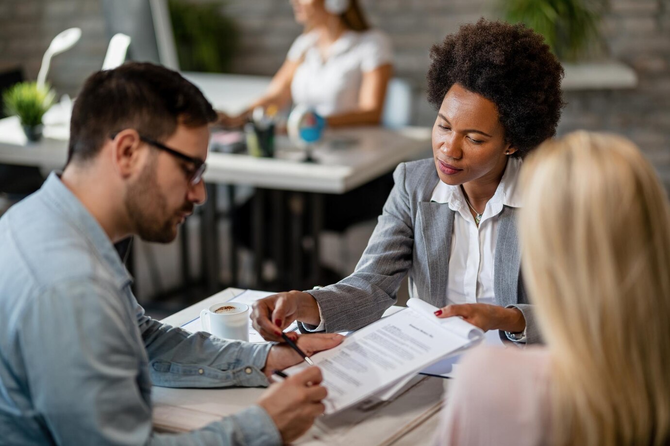 Two property lawyers in Perth engage in a discussion over paperwork in a professional office environment.