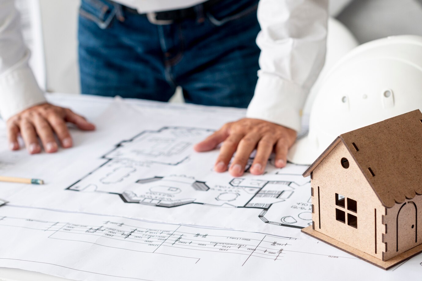 A man with a house model and blueprint, illustrating property law practices in Perth.